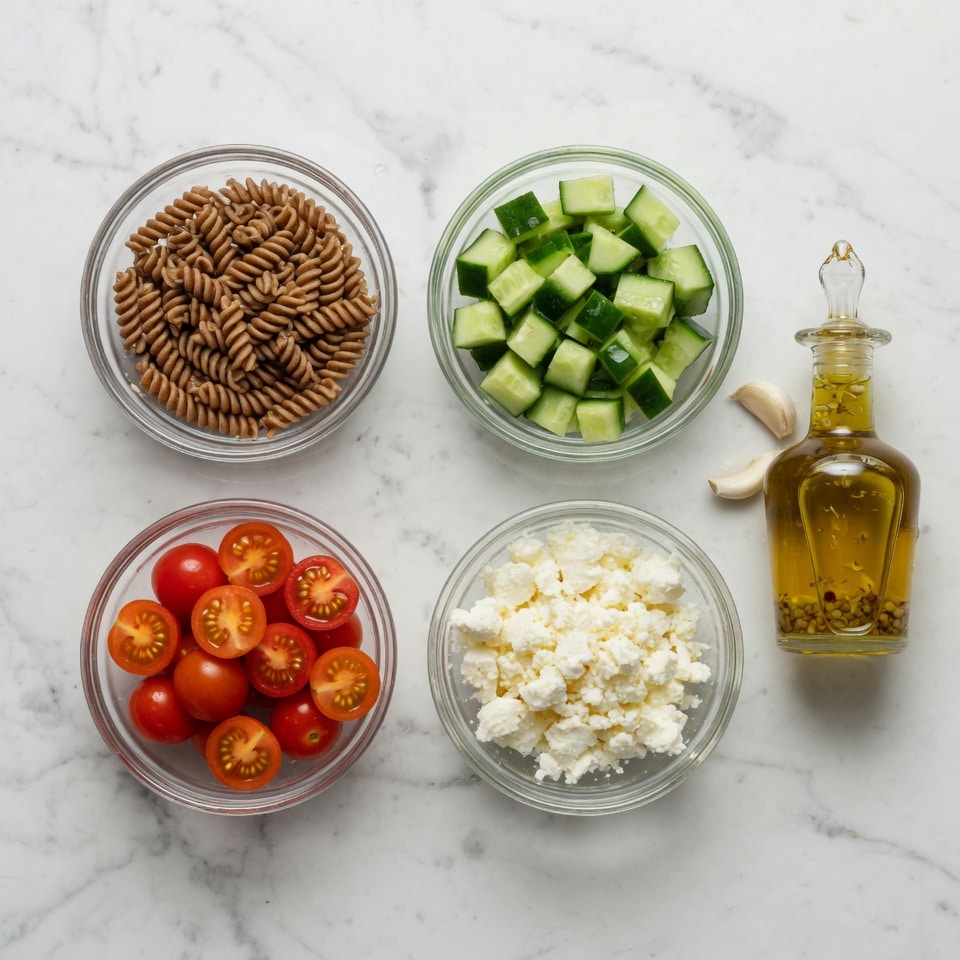 Neatly arranged ingredients for an IBS-friendly salad including gluten-free pasta garlic-infused oil and fresh herbs in glass bowls