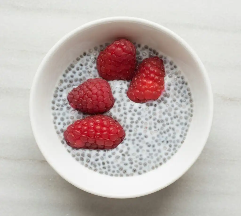 Low FODMAP chia pudding with raspberries in small bowl