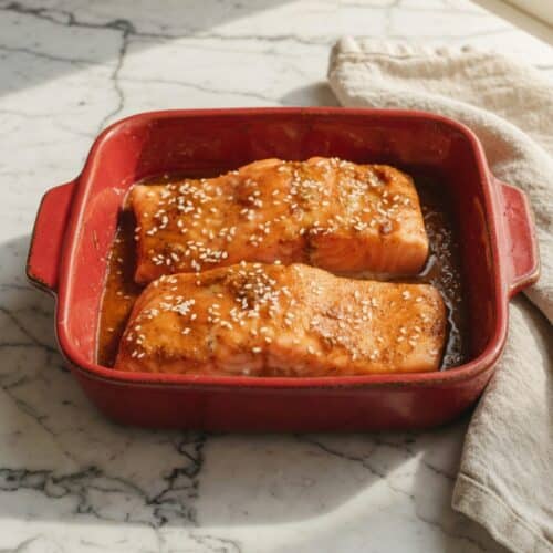 Low FODMAP salmon fillet baked with lemon and dill on a white plate, IBS-safe dinner recipe