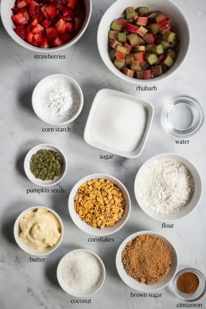 Low FODMAP strawberry rhubarb crumble ingredients flat lay strawberries rhubarb cornflakes