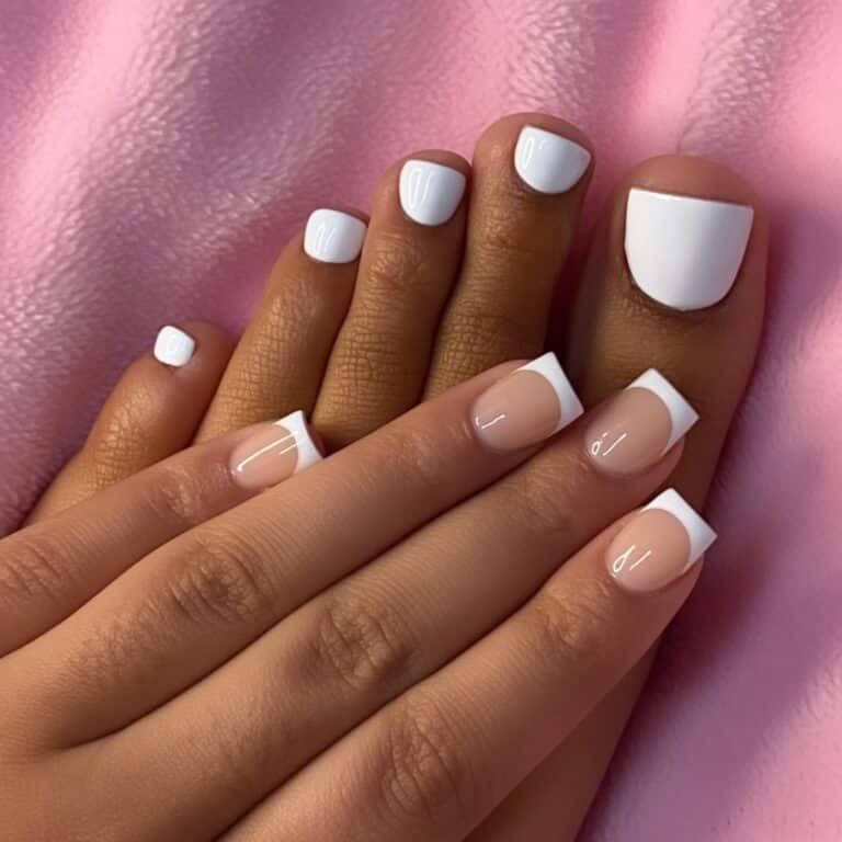 Classic white French tip toes with glossy square toenails on a soft pink towel.
