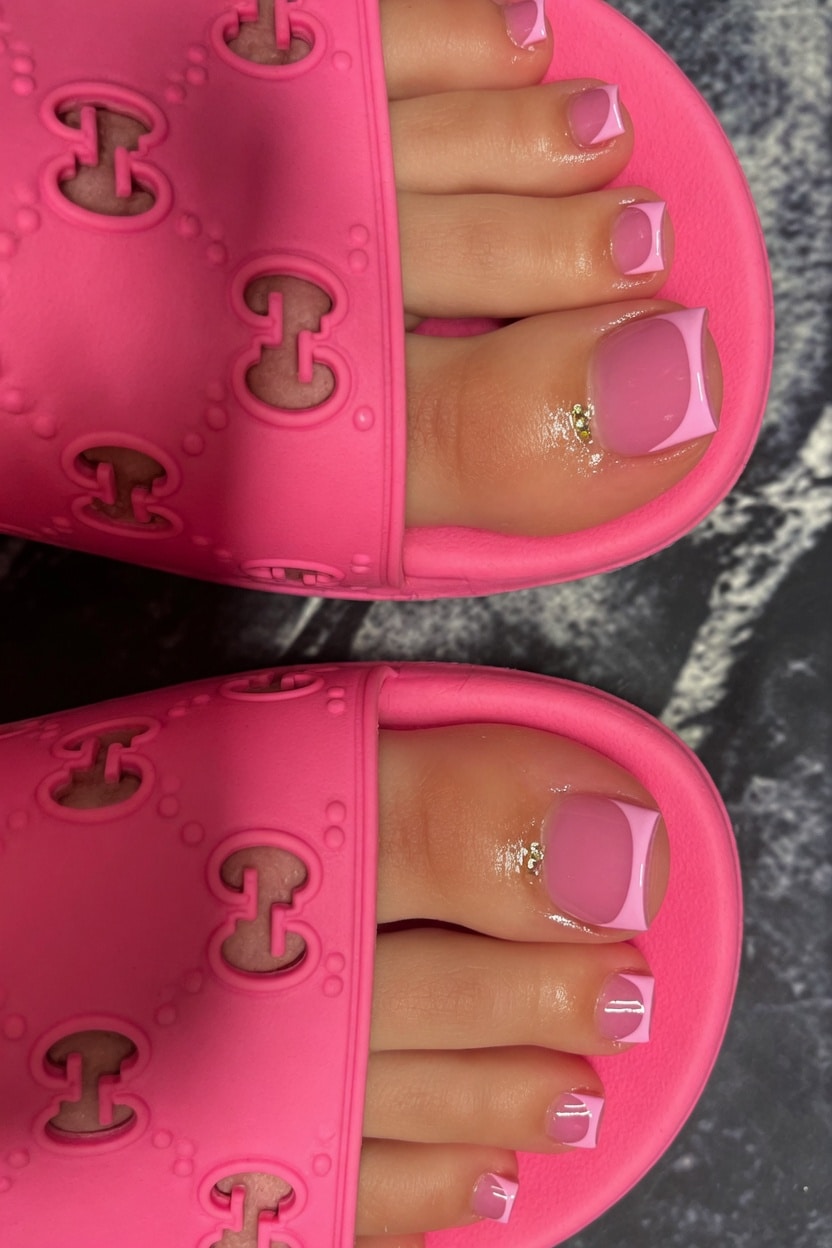 Clear pink French tip toes with a sheer glossy base and soft pink tips in pink sandals.