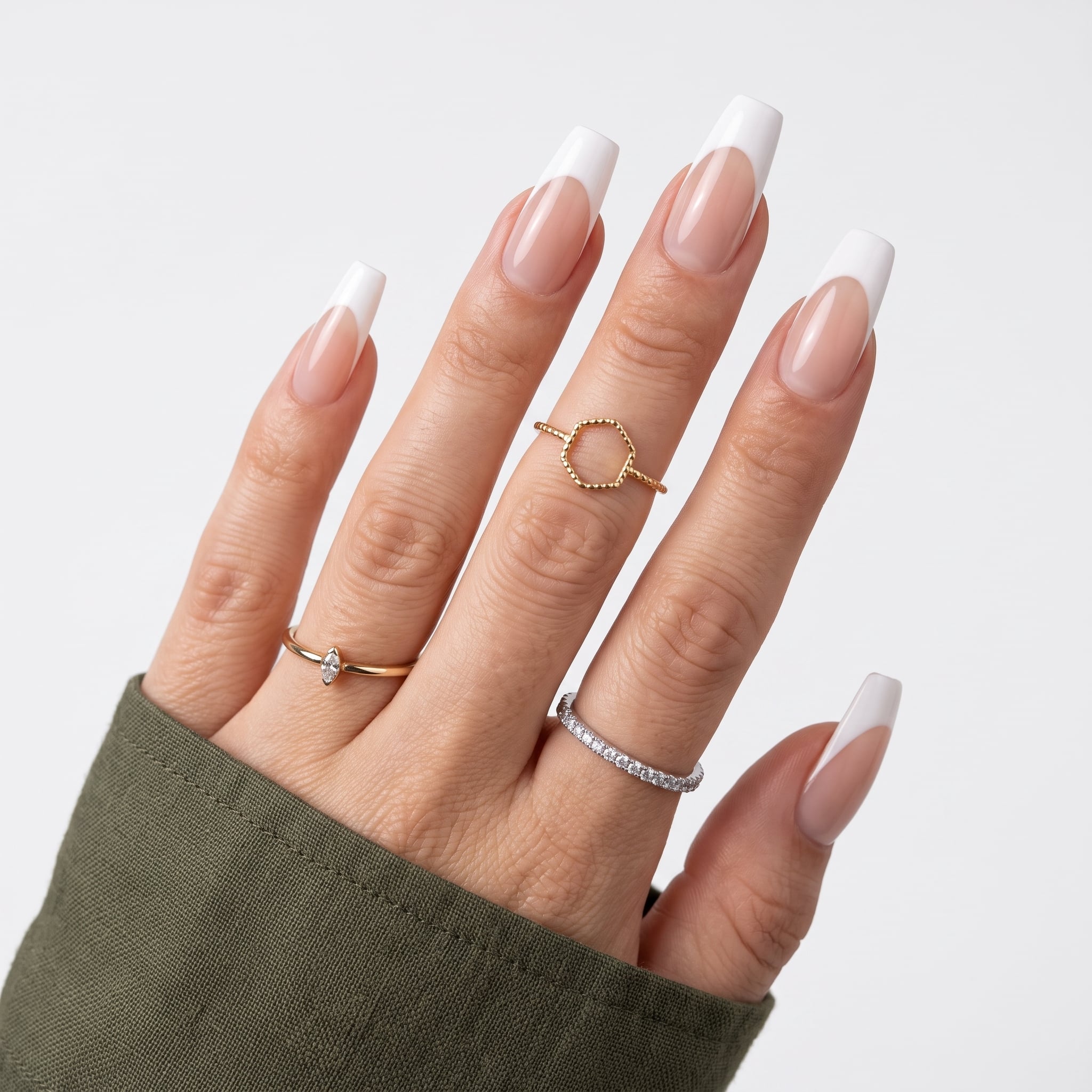 Boxed acrylic press-on nail set with white floral designs and glossy nude bases.