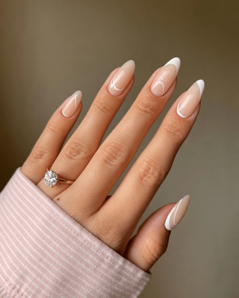 Almond French nails with a sheer nude base and soft white tips