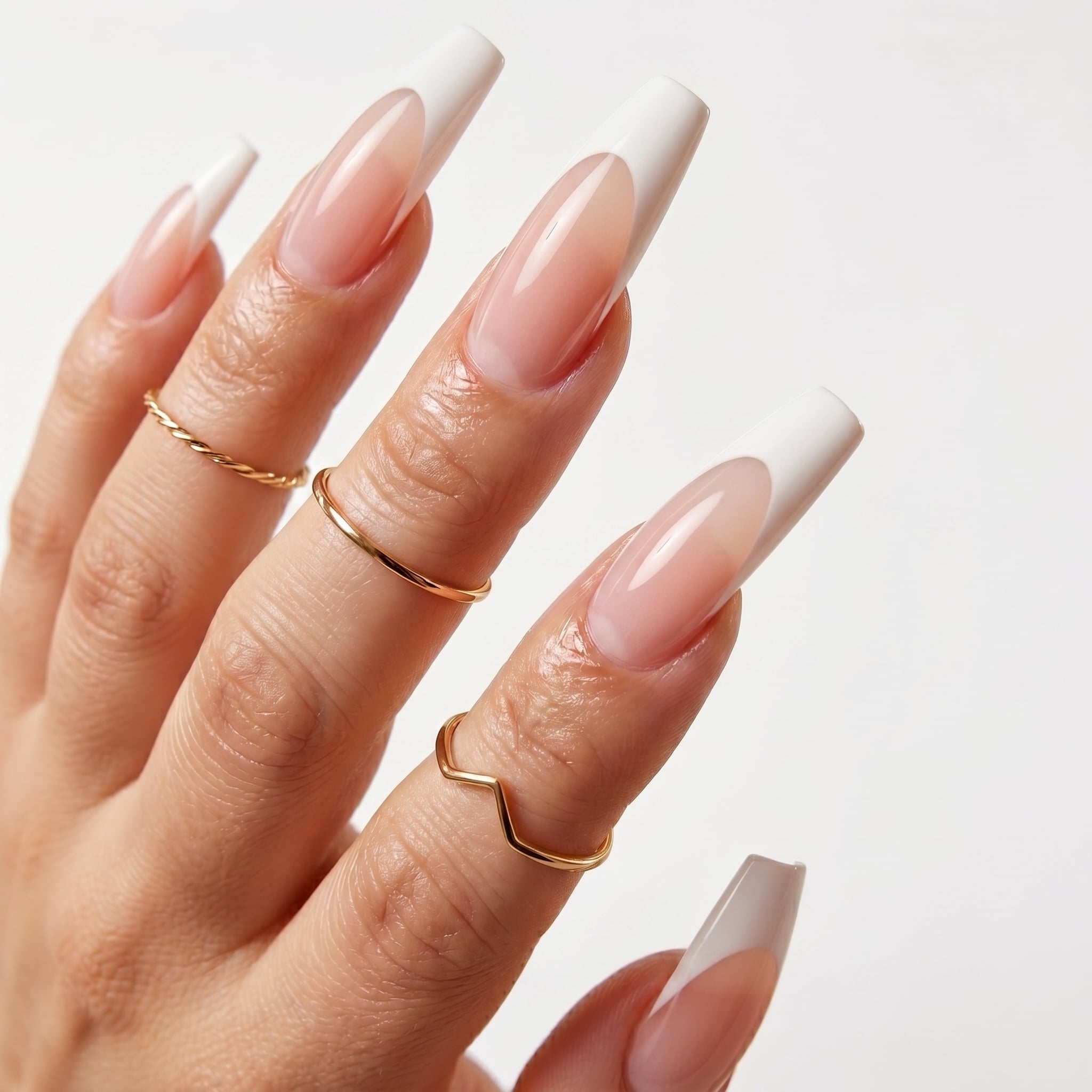 Long almond press-on nails with glossy white French tips and a pink nude base
