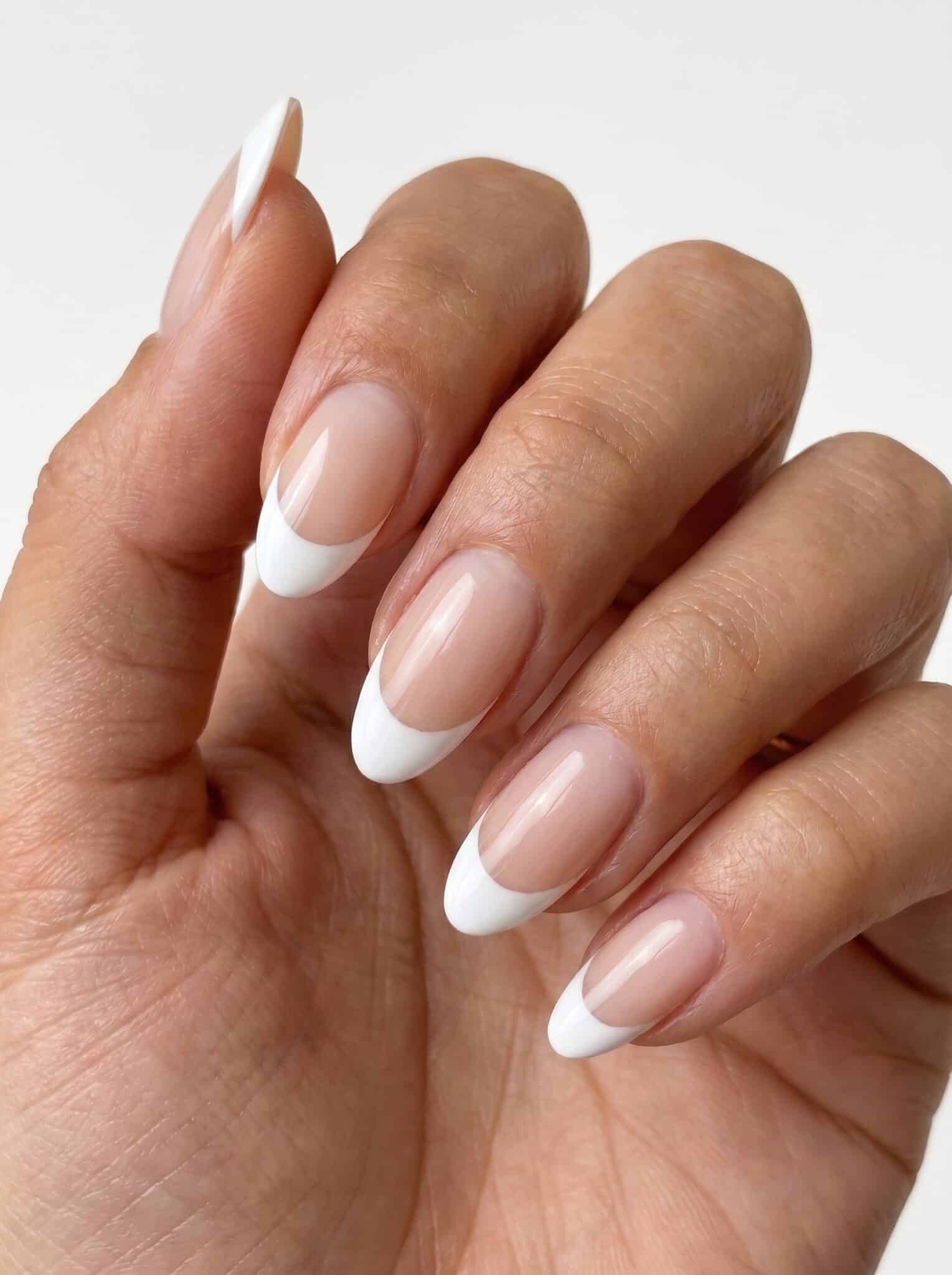 Short rounded nude nails with neat white French tip details