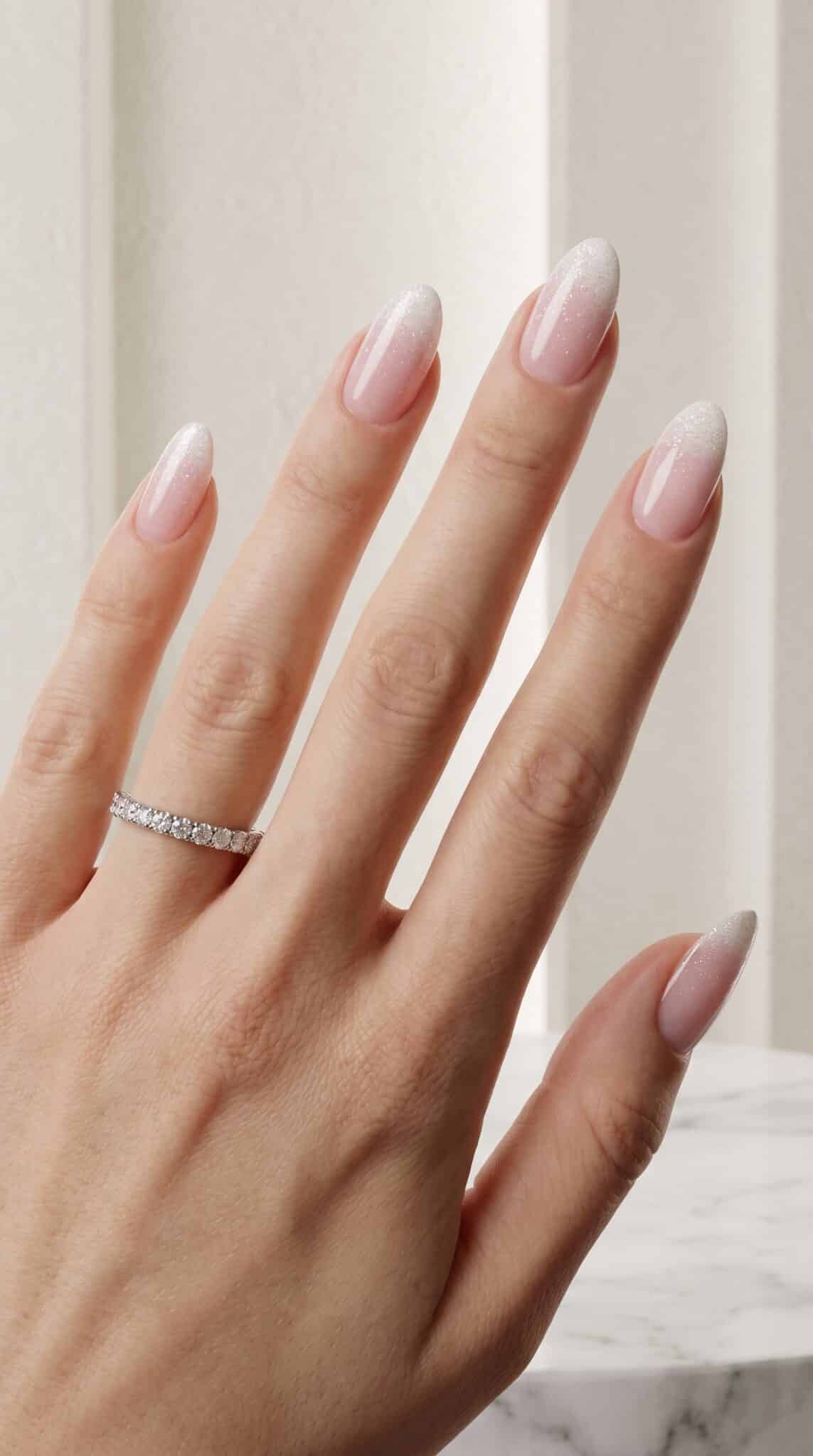 White almond French nails with a sheer pink base and elegant glossy finish