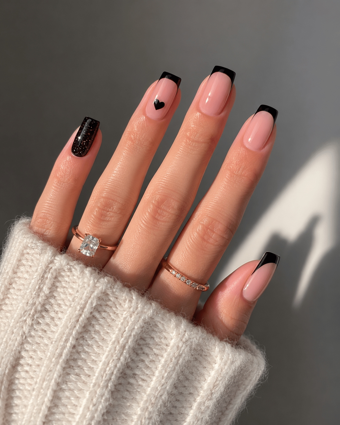 Chic editorial black French tip nails with a nude base and glossy finish
