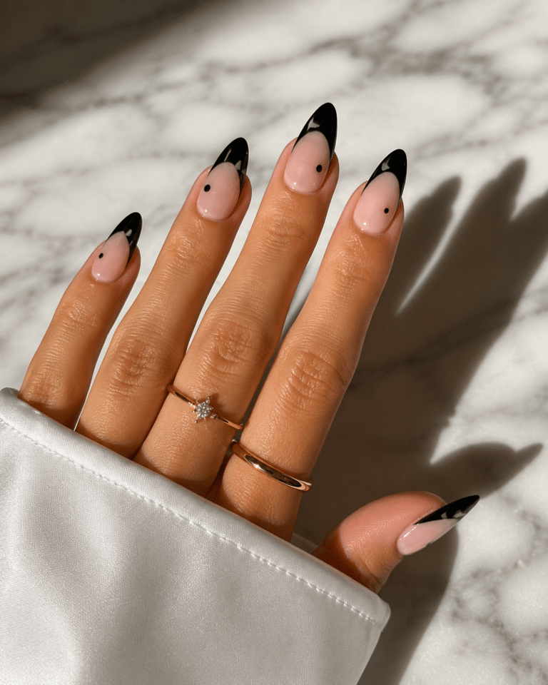 Black French tip nails with a nude base and glossy almond shape