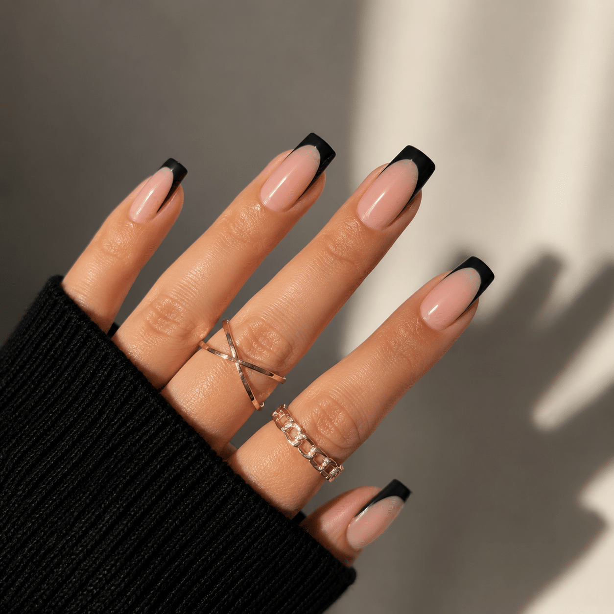 Modern black French tip nails with a nude base and clean glossy detail