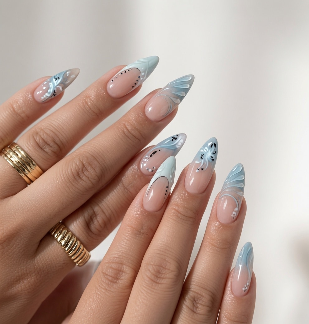 Medium almond nude press-on nails with glossy cobalt blue French tips, held beside a white knit sleeve.