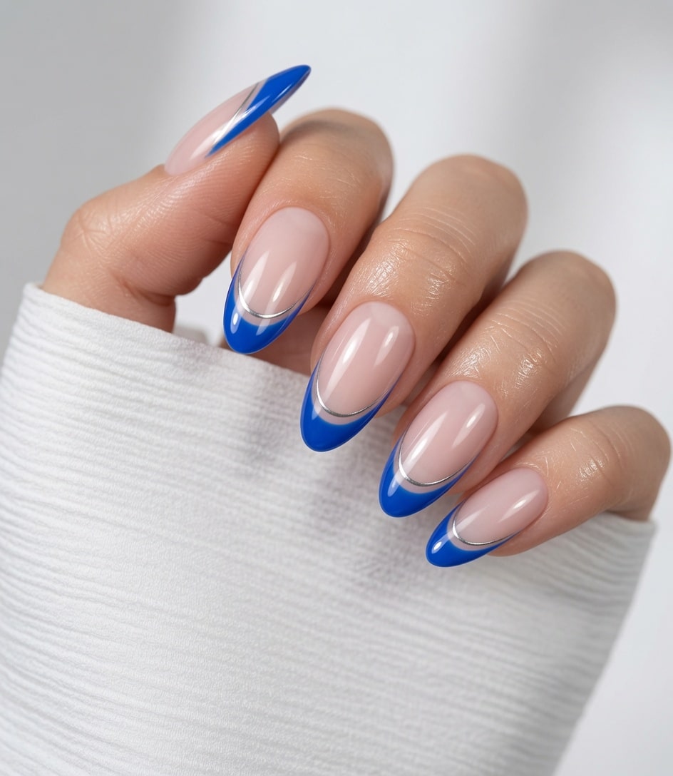 Short nude nails with soft light blue French tips on a raised hand.