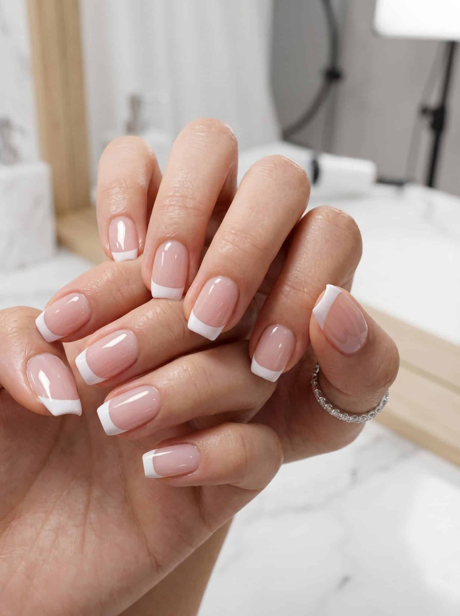Colorful short summer French tips with bright pastel accents on a nude base