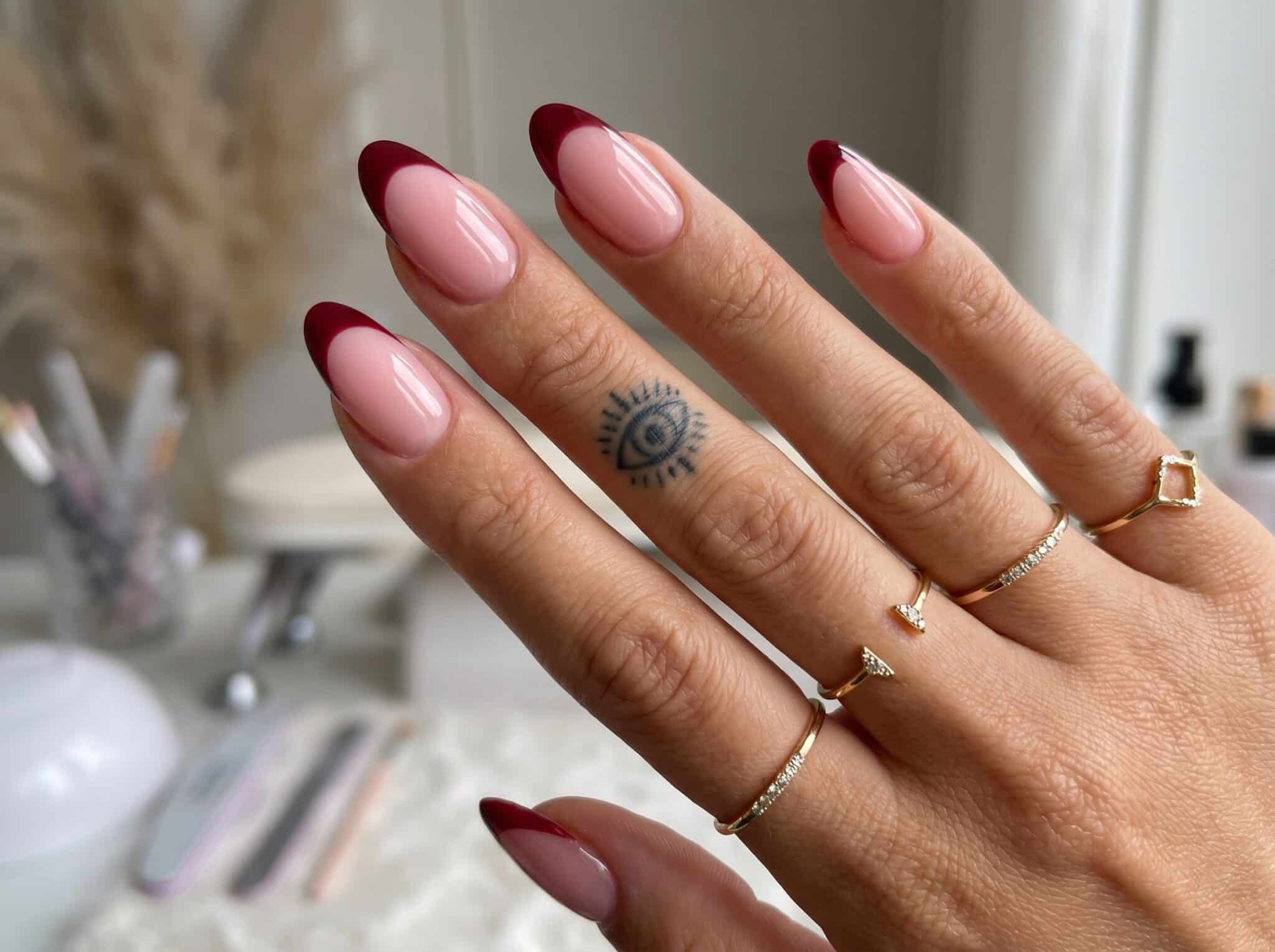 Colorful pastel French tip nails on almond nails with a soft salon-style background