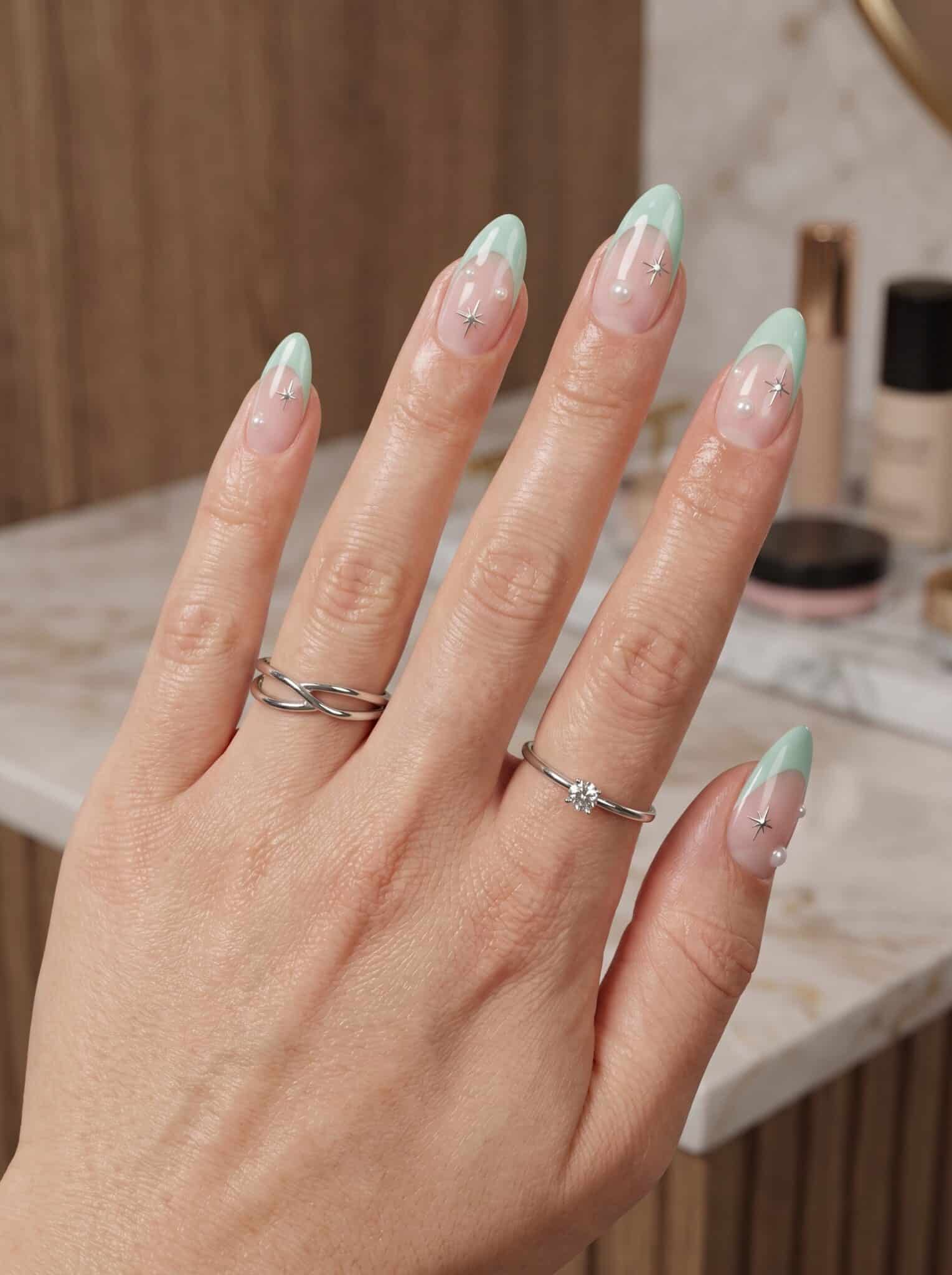 Pastel blue and pink French tip nails on glossy almond nails in a vertical beauty image