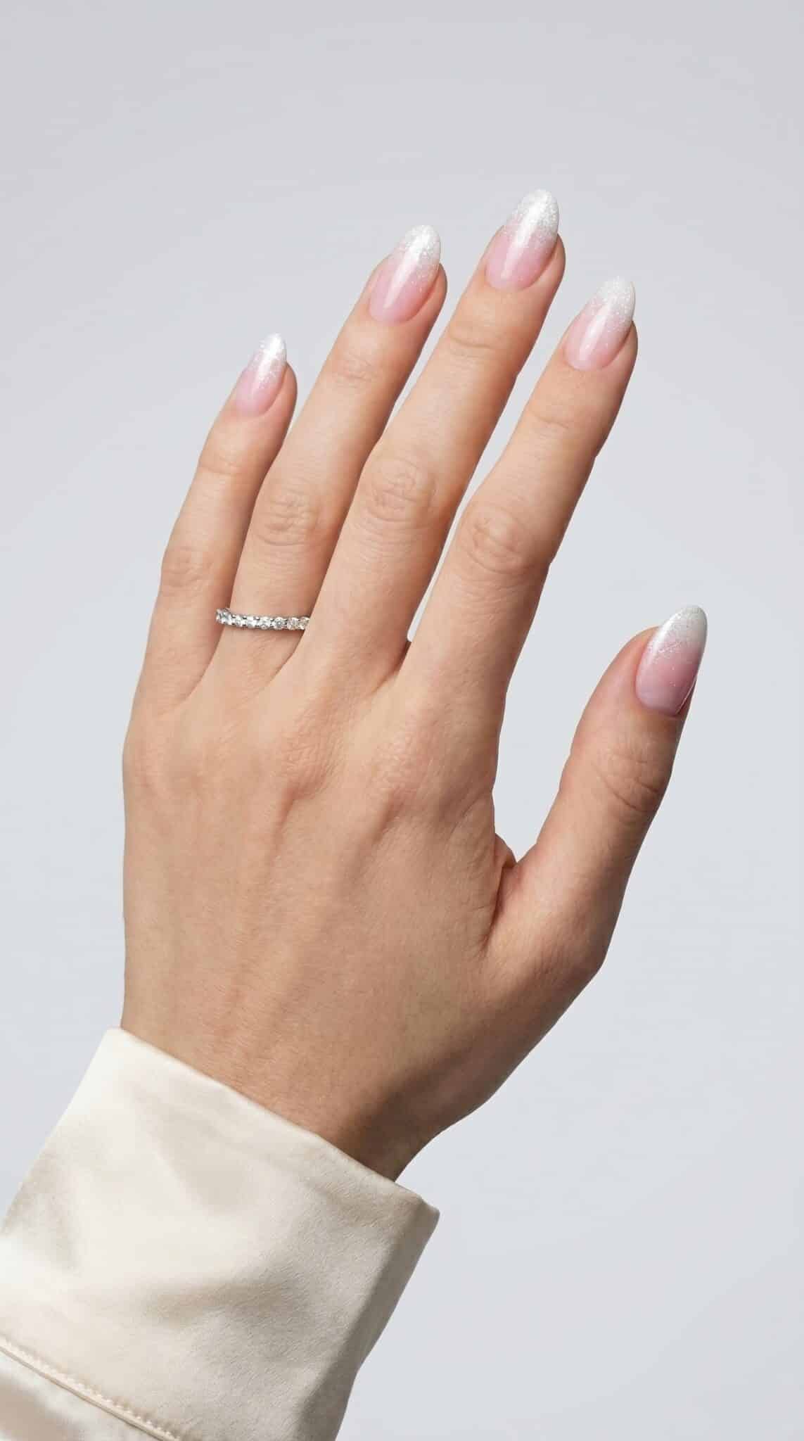 Painting thin French tips on almond nails with a detail brush and glossy nude base