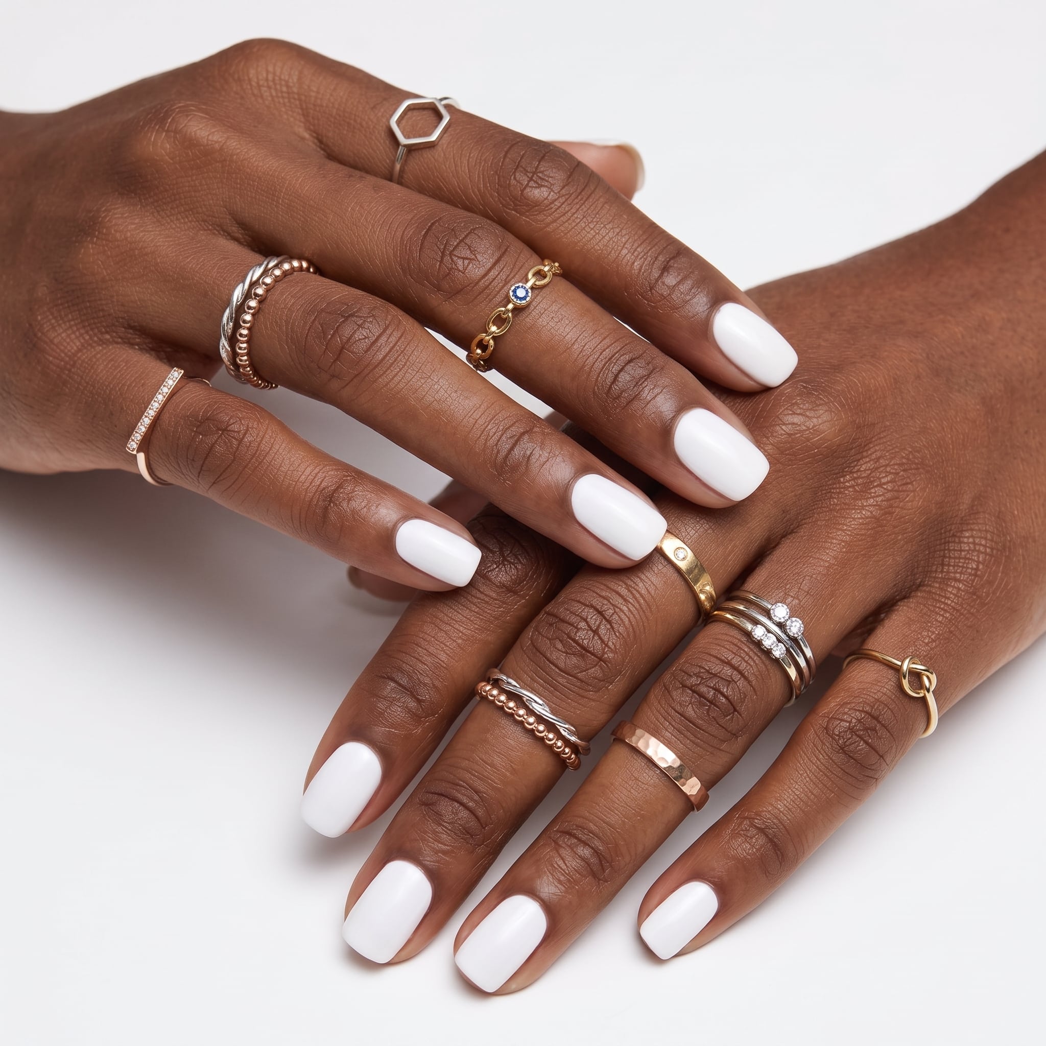 Black extra short press-ons styled with a warm rust sweater sleeve and slim gold rings.