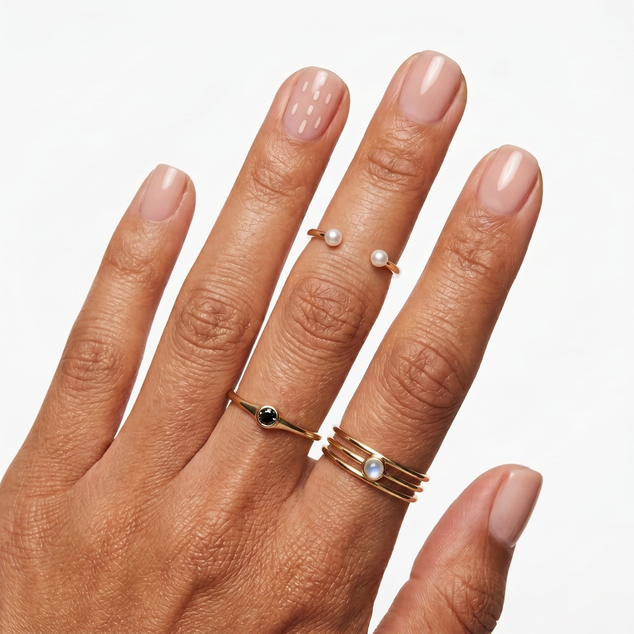 Natural pink extra short press-ons with a glossy nude finish on one hand.