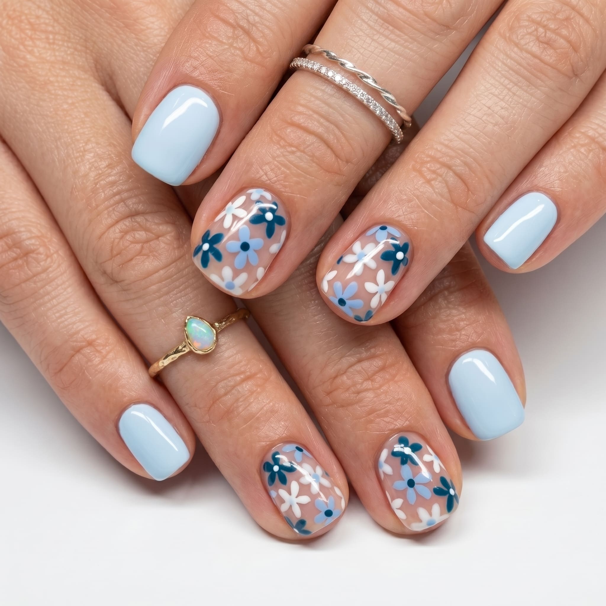 Nude extra short press-ons on deep skin tone with a glossy natural finish and delicate rings.