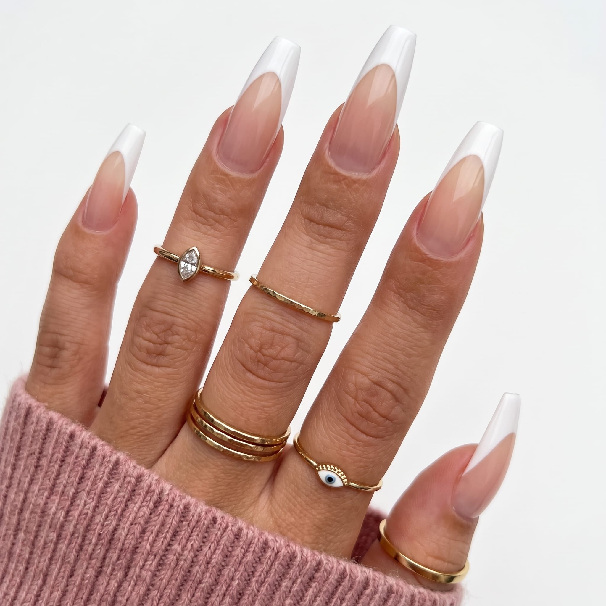 Glossy French press-ons with white tips, nude-pink bases, and a soft white sleeve detail.
