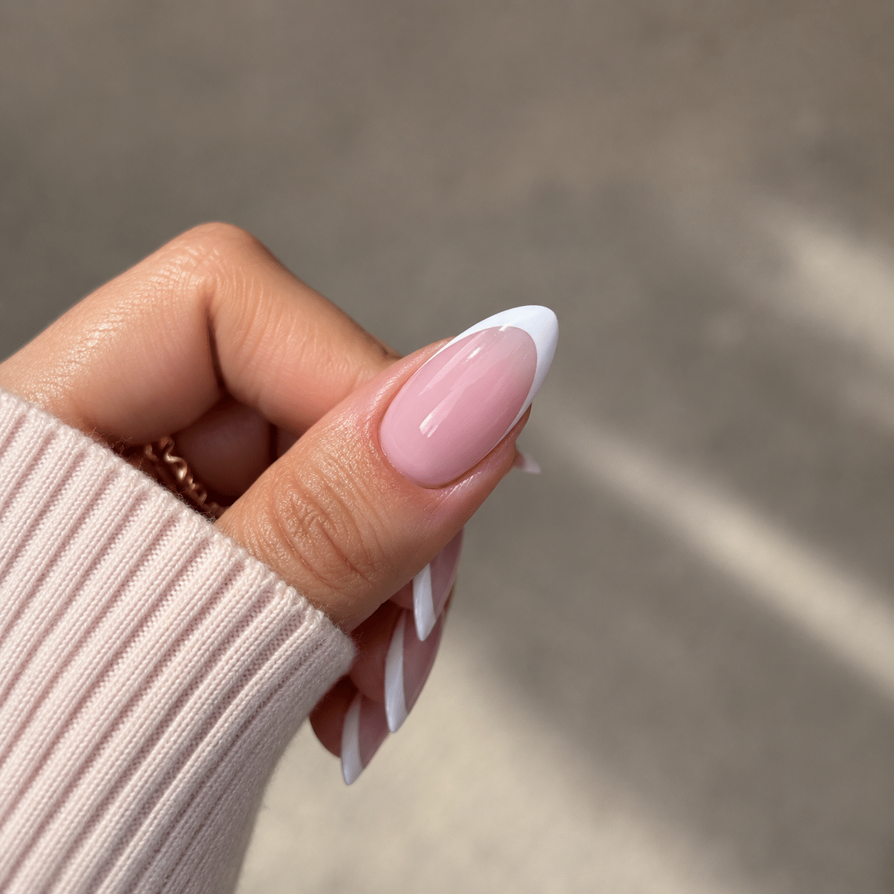 Milky white almond French nails with a glossy soft finish.