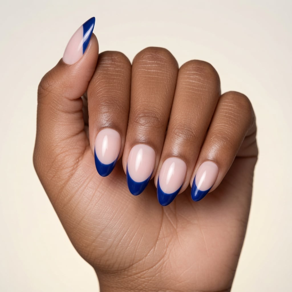 Navy blue almond French tip nails with a glossy nude base
