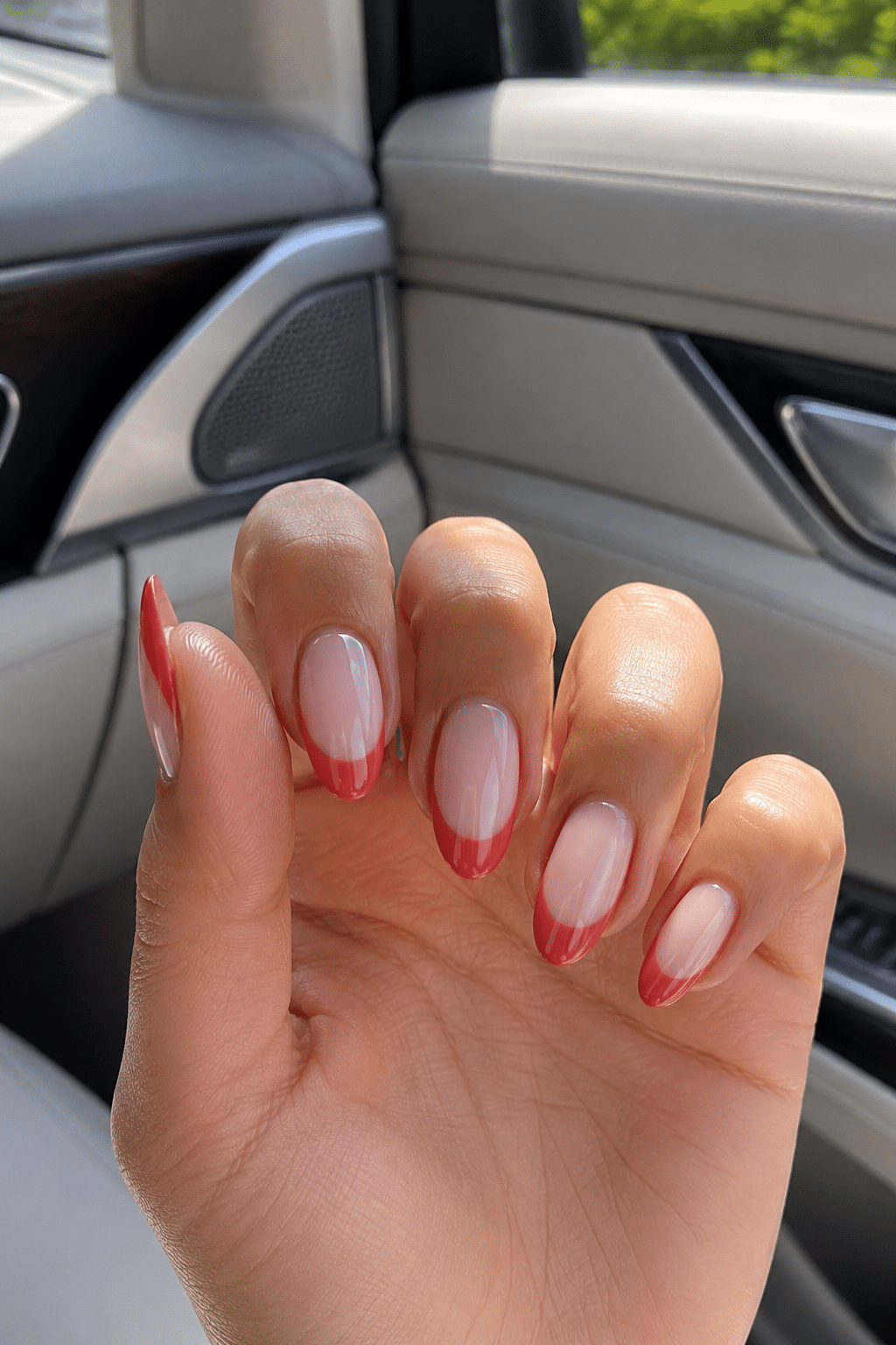Orange almond French tip nails with a soft nude base and precise orange tips