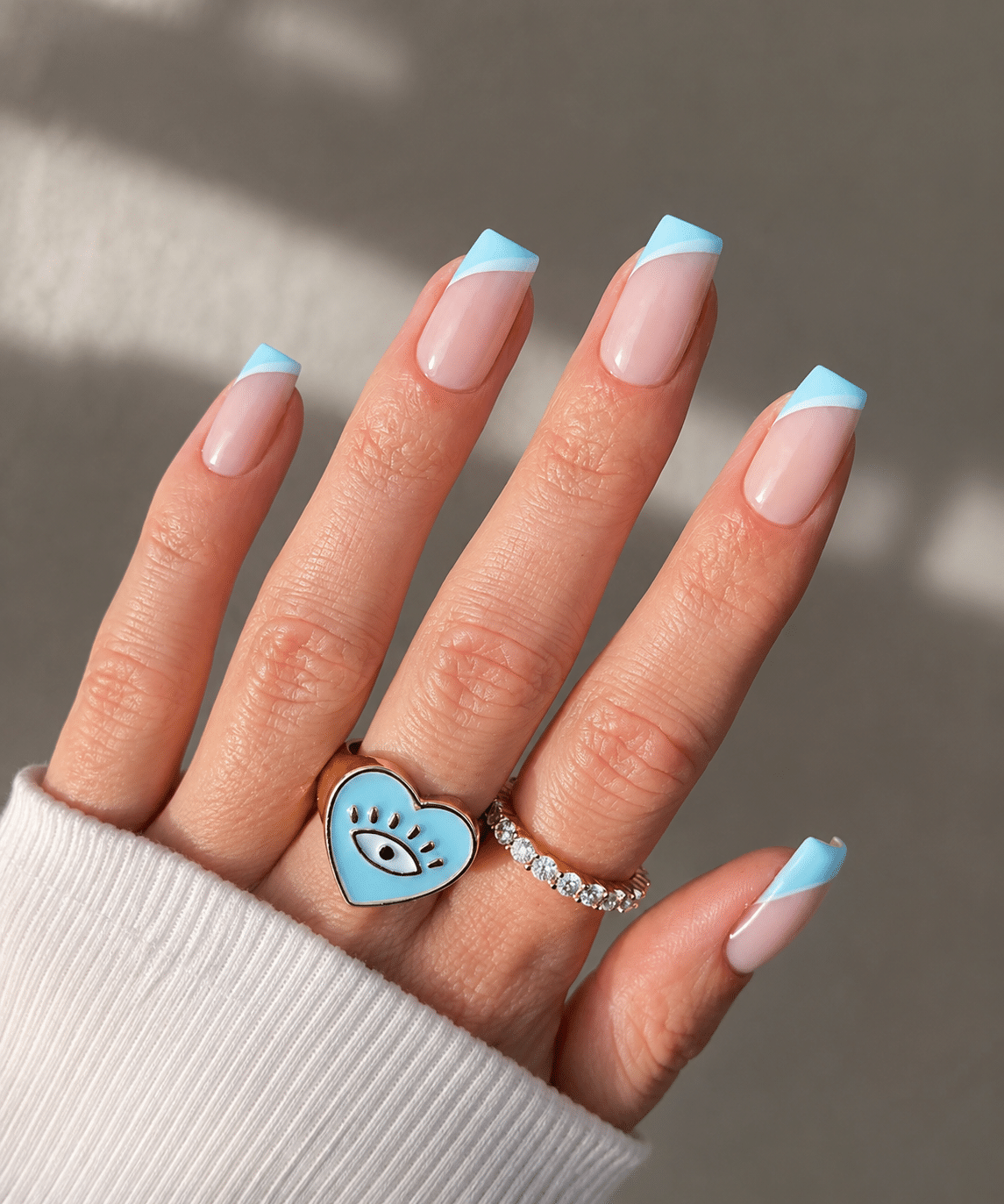 Pink French tip nails with soft almond shape and glossy nude base