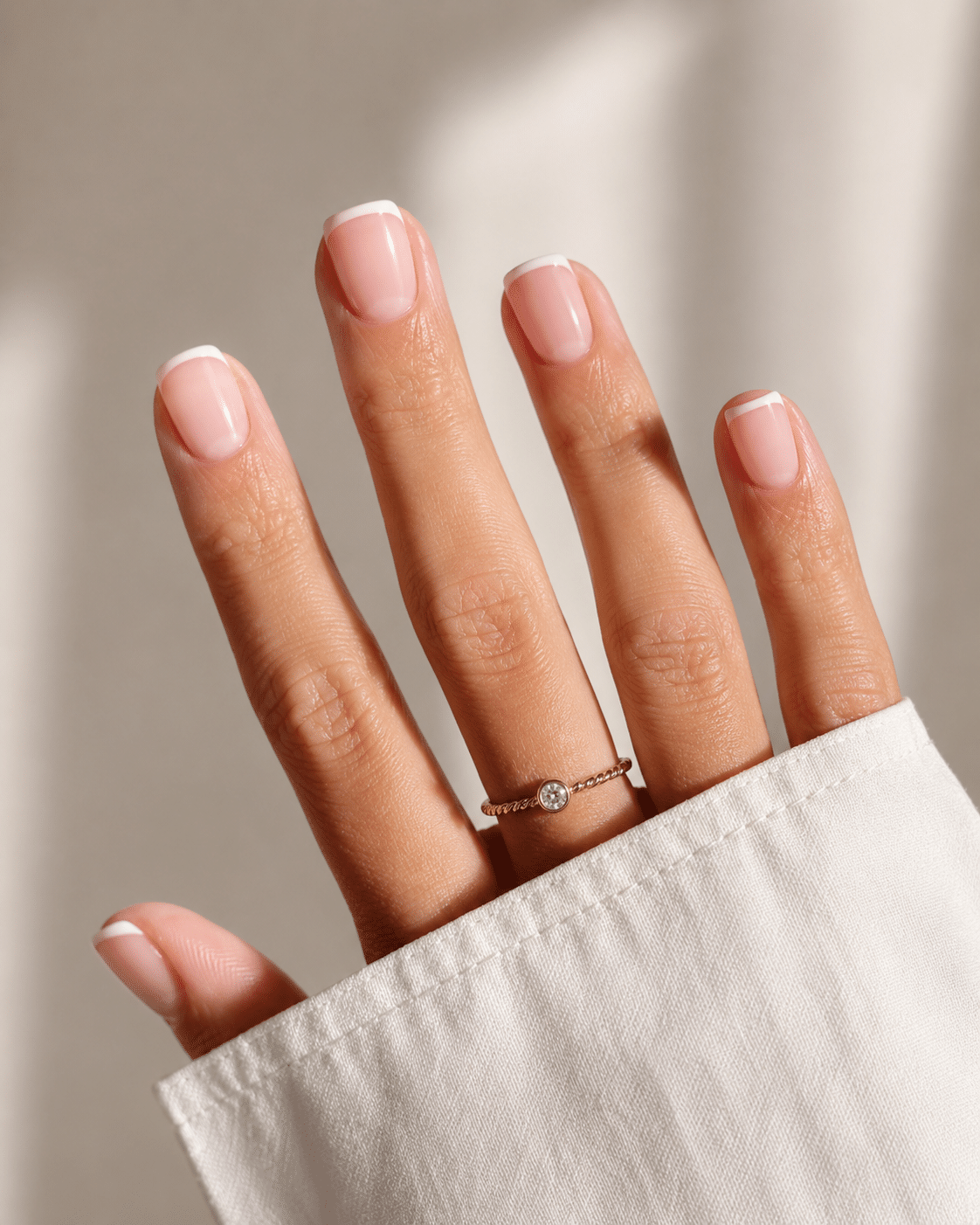 Soft square short French tip nails with a sheer nude base and crisp white tips