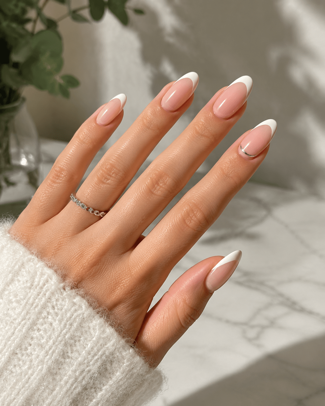 Skinny French tips on almond nails with a soft pink base