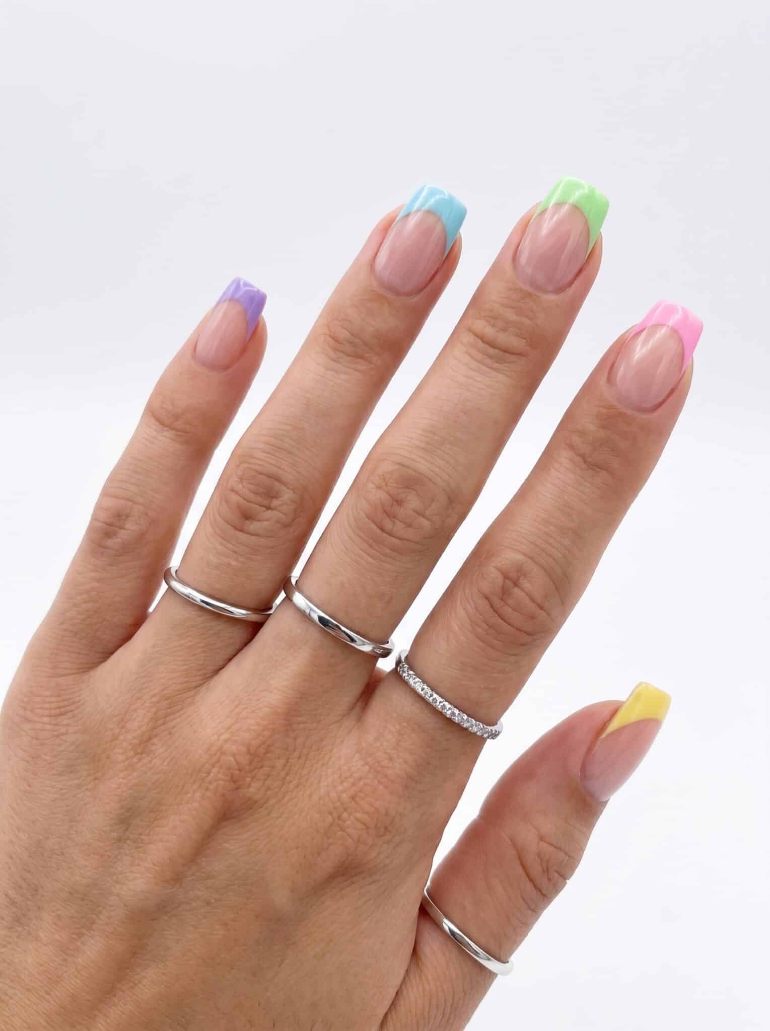Pink summer French tip nails with tiny floral accents and glossy almond shape