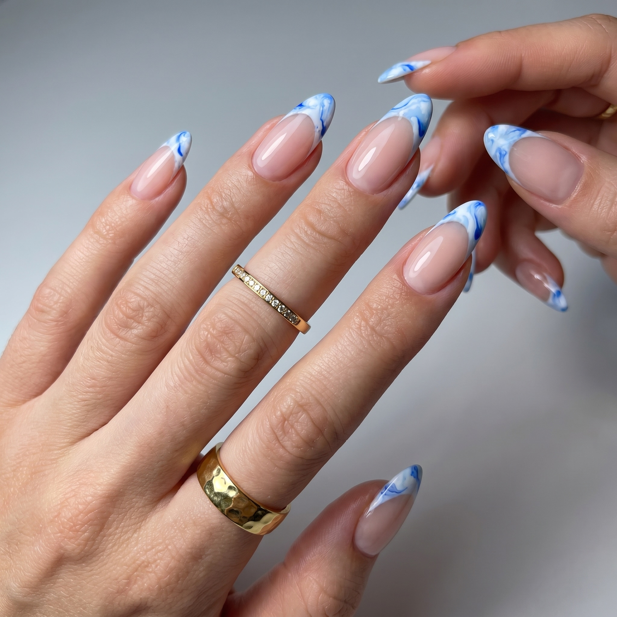 Blue summer French tip nails with a sheer nude base and glossy almond shape