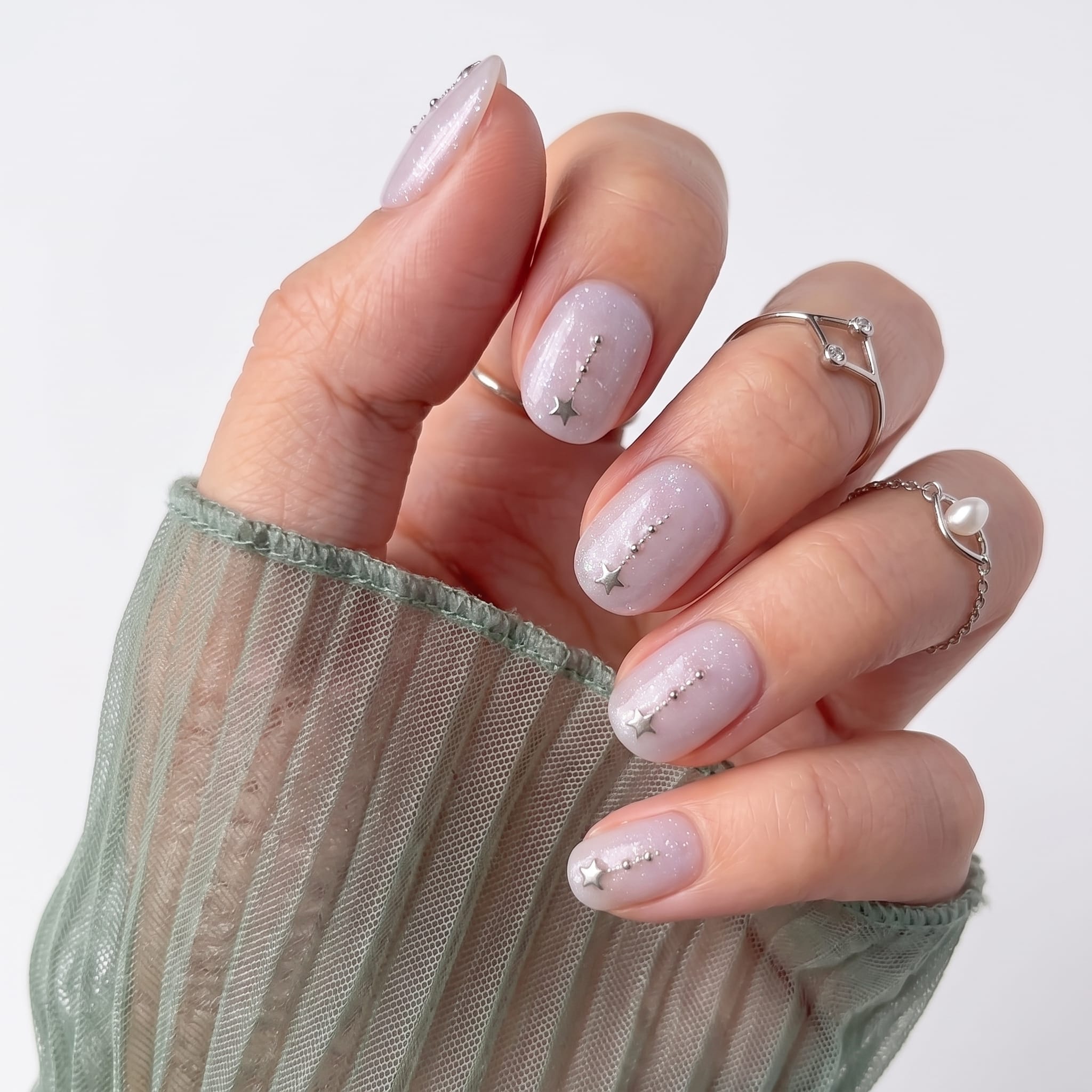 Soft white short nails with delicate speckled pink nail art