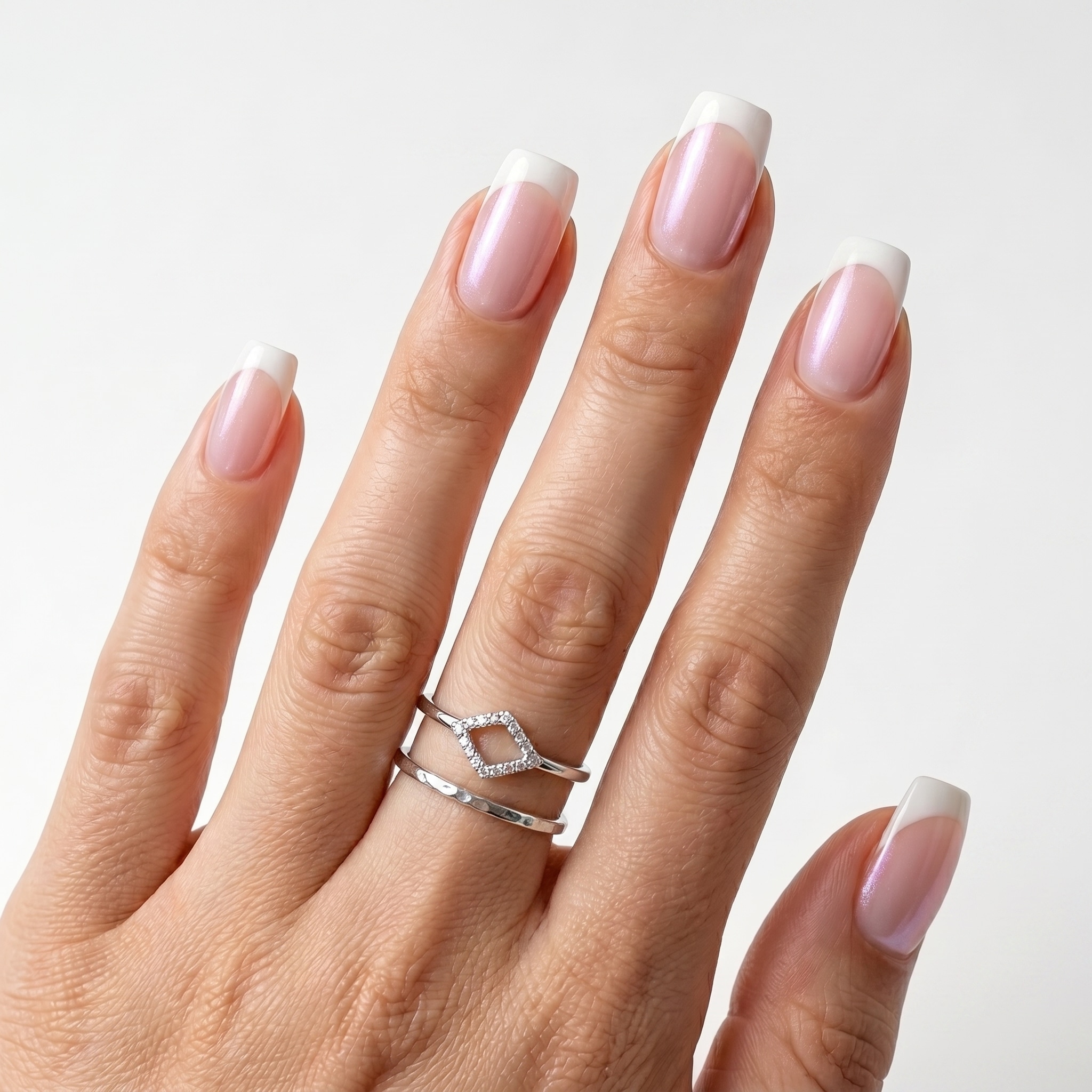 Long nude square nails with slim white French tips and a glossy finish