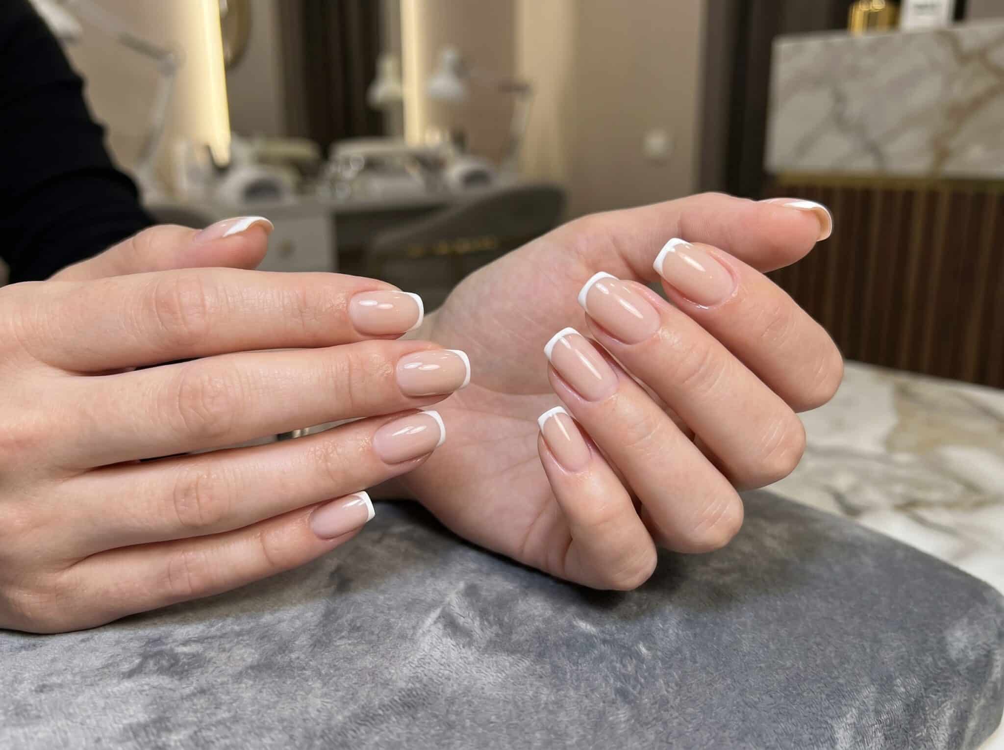 Hands showing short coffin French tips as a step-by-step manicure reference
