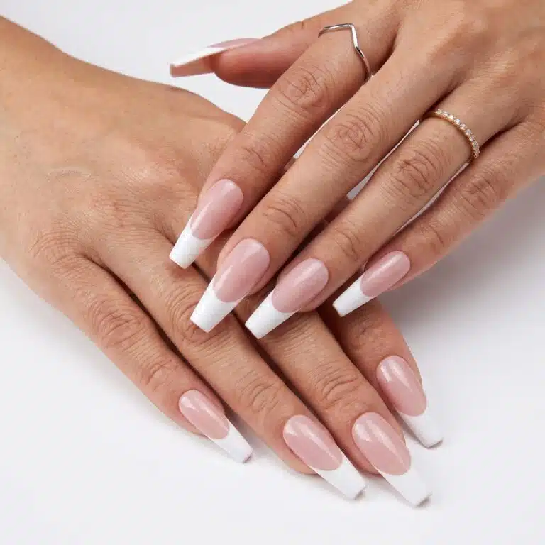 13 Press-On French Nails for a Clean Salon Look 3 Minimal almond French press-ons with soft white tips and a natural glossy pink base on one hand.