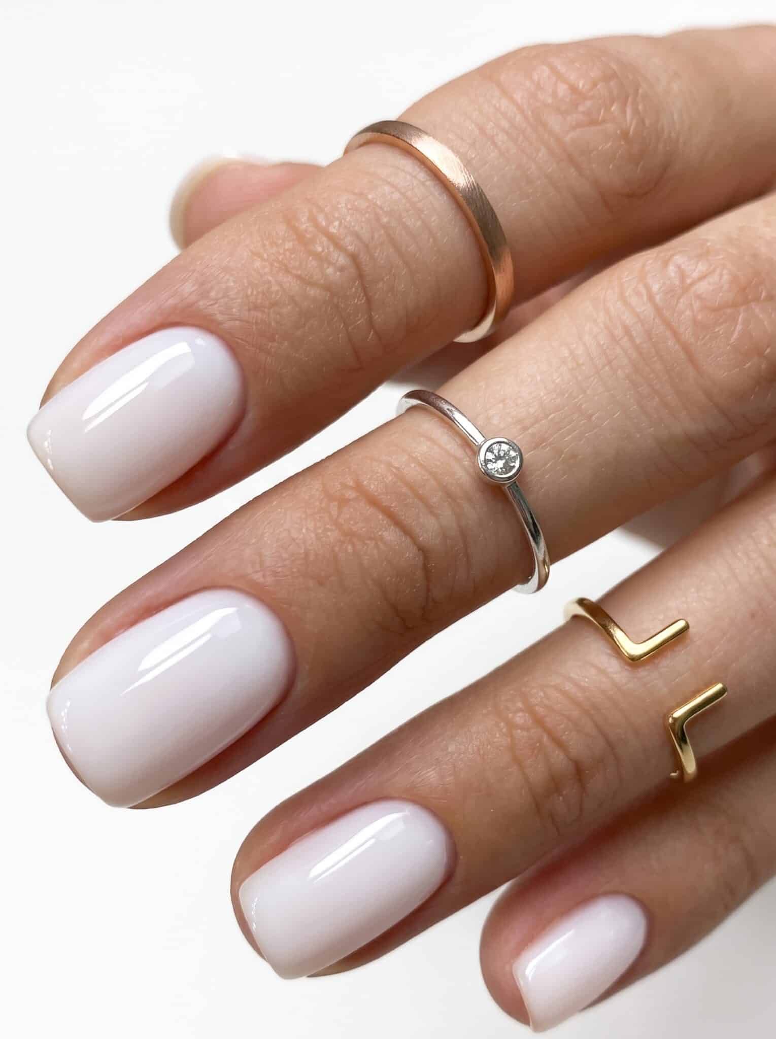 Long square white press-ons with crisp opaque tips and delicate gold ring styling.