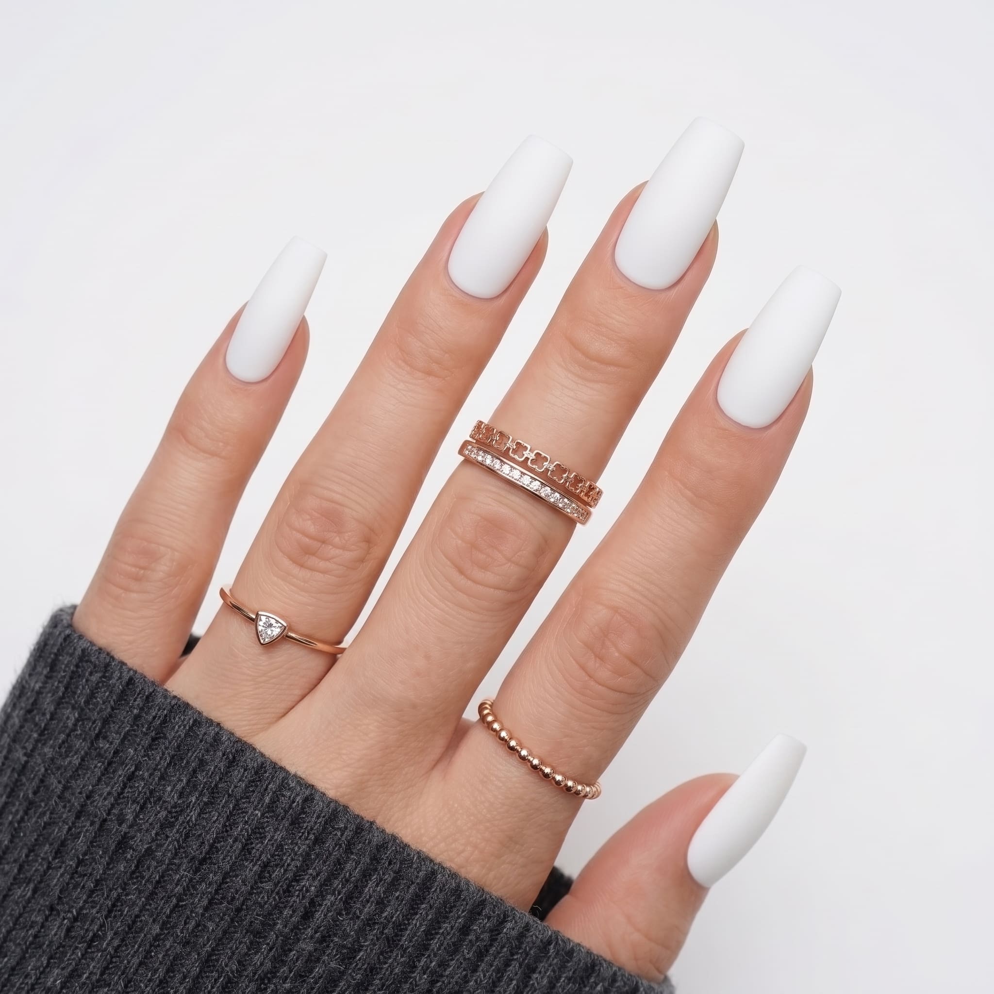 Long stiletto white press-ons with a bright opaque finish and nude base styling.