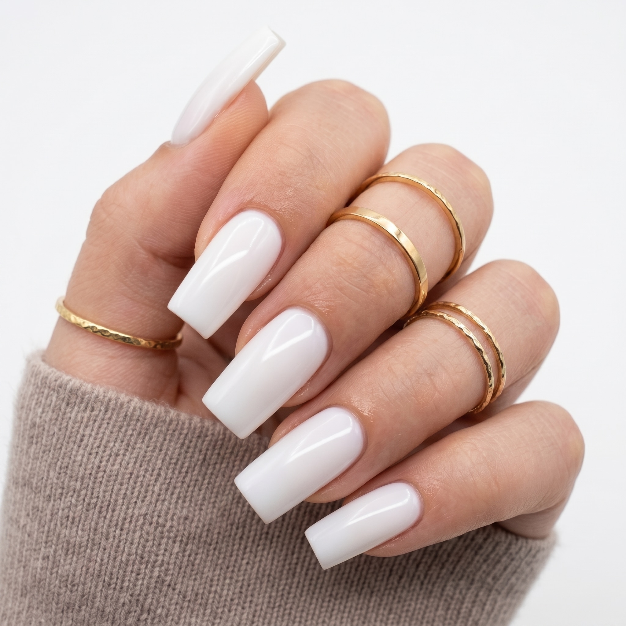Short square white press-ons with bright opaque tips and gold ring styling.