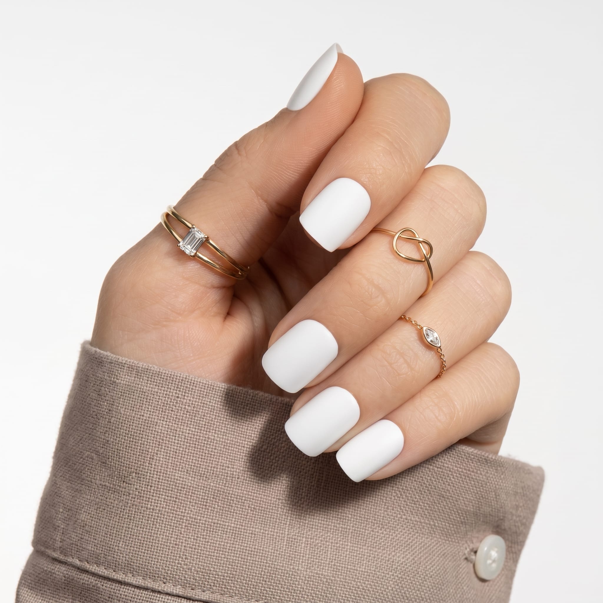 Clean square white press-ons with bright tips, nude base, and delicate rings.