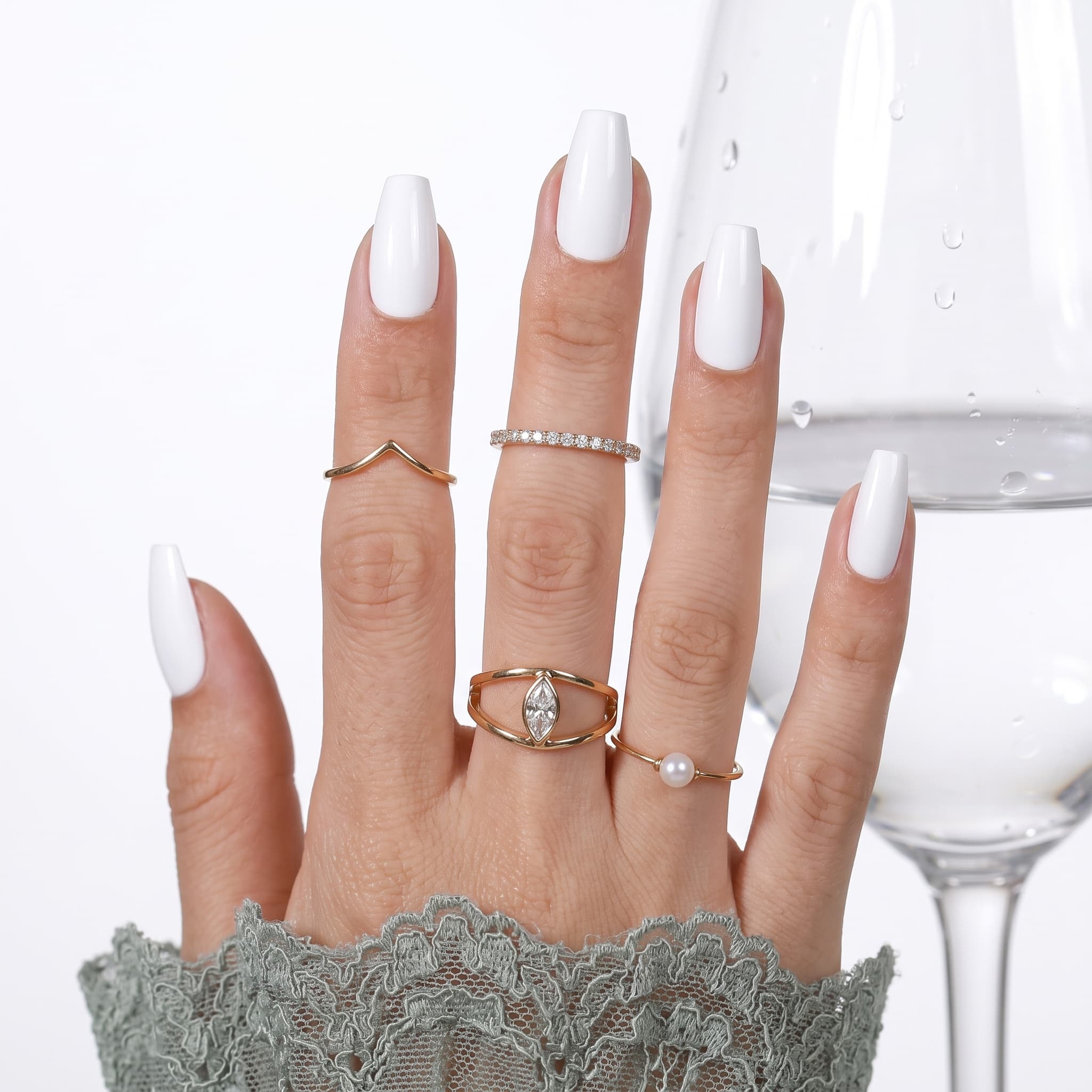Pearl white almond press-ons with a soft shimmer finish and beige sleeve styling.