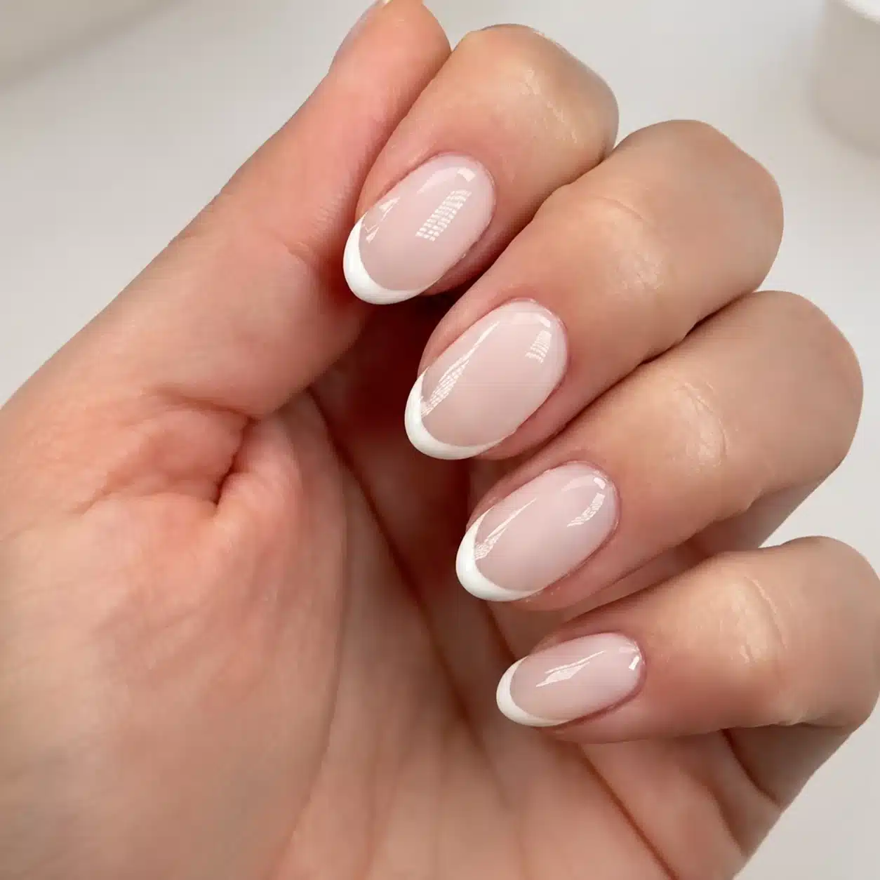 French Tip Nail Polish: Best Colors, Formulas & DIY Guide 2 Classic white French tip nail polish over a sheer nude base