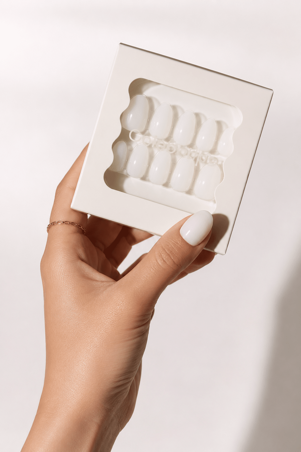 Sheer milk press on nail kit with short almond nails in an open box