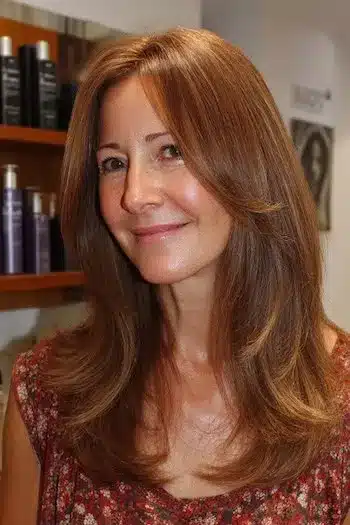 A woman over 50 with fine hair wearing piecey face-framing layers, showcasing one of the 30 inspiring long hairstyles for women over 50 with fine hair.