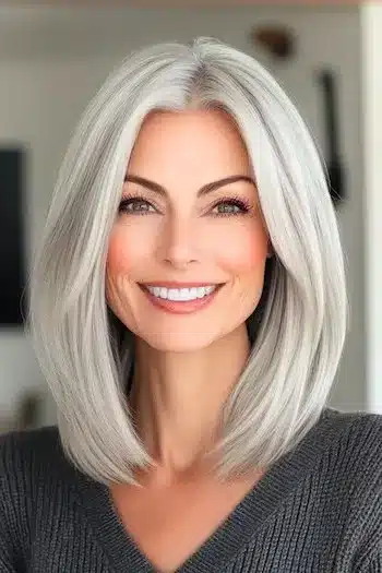 Sleek Silver Lob Haircut on a smiling woman with gray hair.
