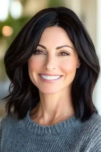 Shoulder-Length Layered Cut for Thick Hair Haircut on a smiling woman with dark brown hair.
