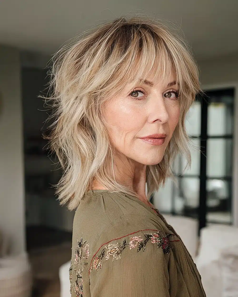 Chin-length shag haircut with bangs and choppy layers for textured volume on mature women, part of 20+ youthful shaggy hairstyles women over 50 are wearing in 2026