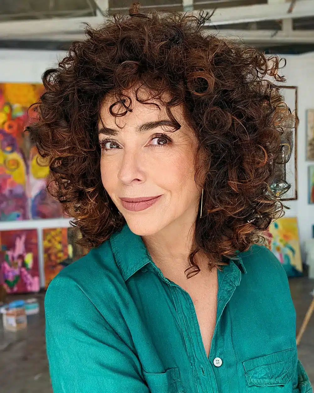 Short shaggy haircut for naturally curly hair with defined layers and volume for older women, featuring 20+ youthful shaggy hairstyles women over 50 are wearing in 2026