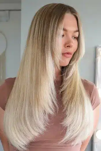 Woman with long face-framing layers showcasing fresh summer haircuts