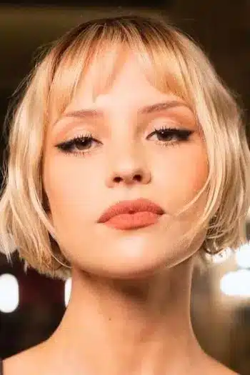 Chin-length French bob haircut on a woman with blonde hair, featured in 32 Iconic French Bob Haircuts That Never Go Out of Style - Parisfy